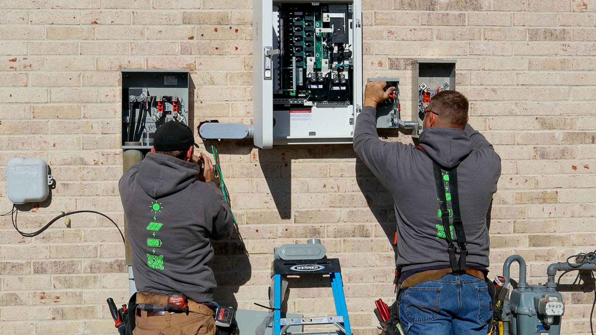 Good Faith Energy technicians working on an electrical panel