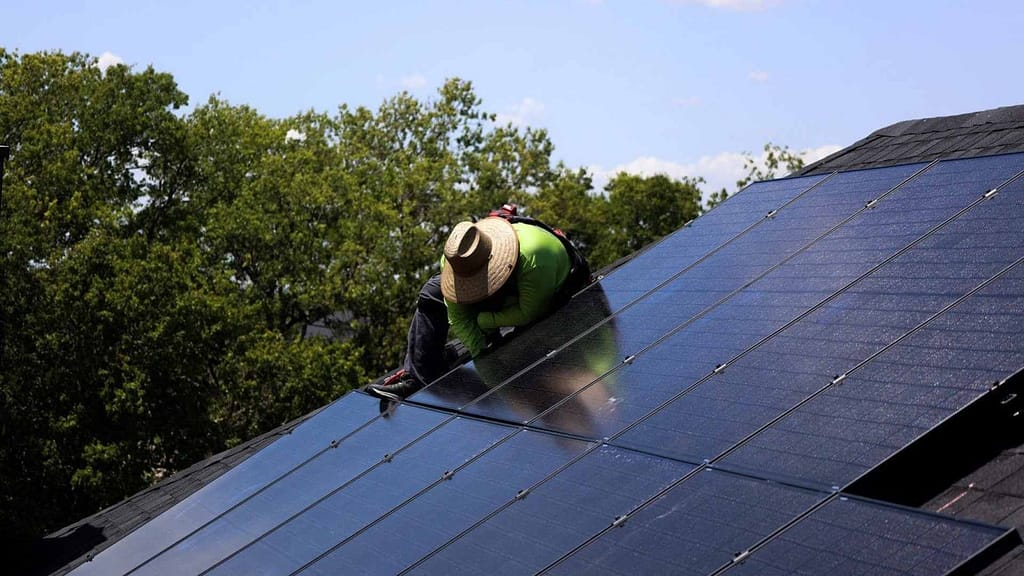 Solar panel installer in green neon uniform