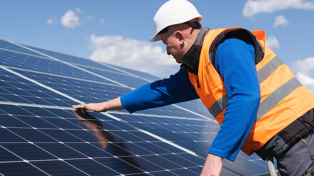 person checking the solar panels