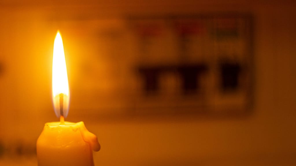 photo of a candle and electrical switch during blackout