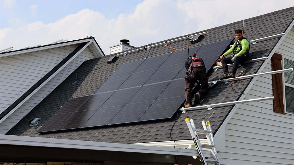 installing solar panel on slope roof by two Good Faith Energy installers