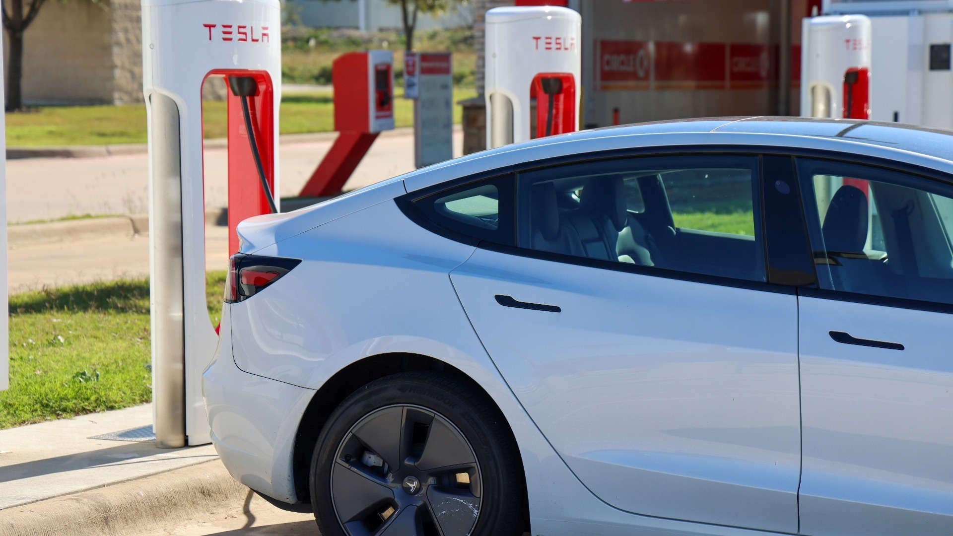 Tesla EV chargers with vehicle at a charging station