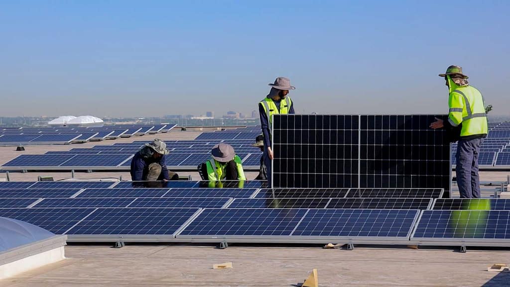 solar installers installing commercial solar panels on a business