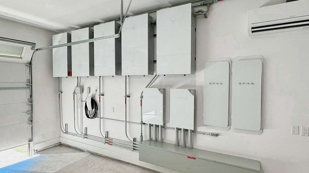 six Tesla powerwall3 in a garage with 2 span smart panels and a electric car charger