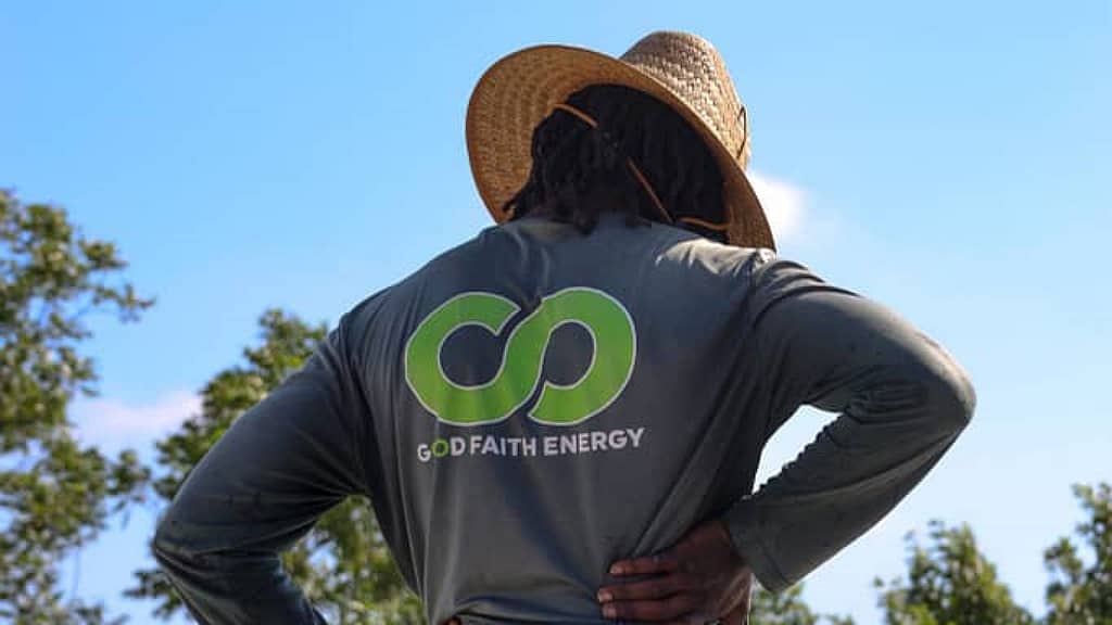 Good Faith Energy installer wearing straw hat and gray longsleeves