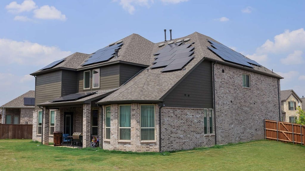 big colored gray house with multiple solar panels installed