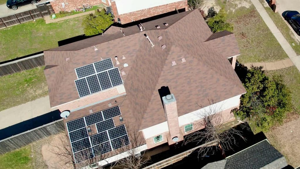 brown roof with multiple solar panels installed aerial view