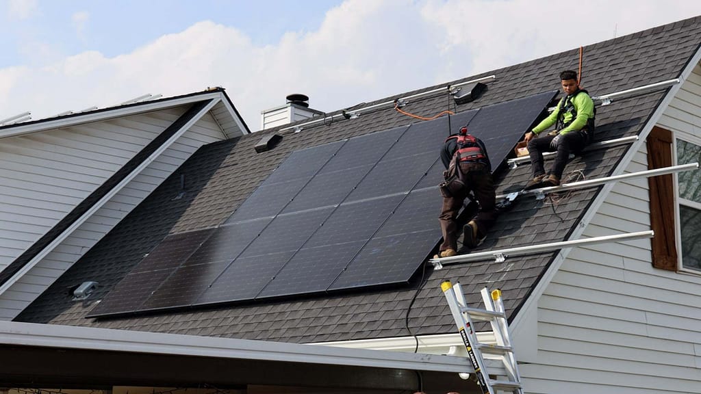 installing solar panel on slope roof by two Good Faith Energy installers