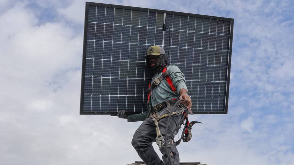roofer carrying solar panel