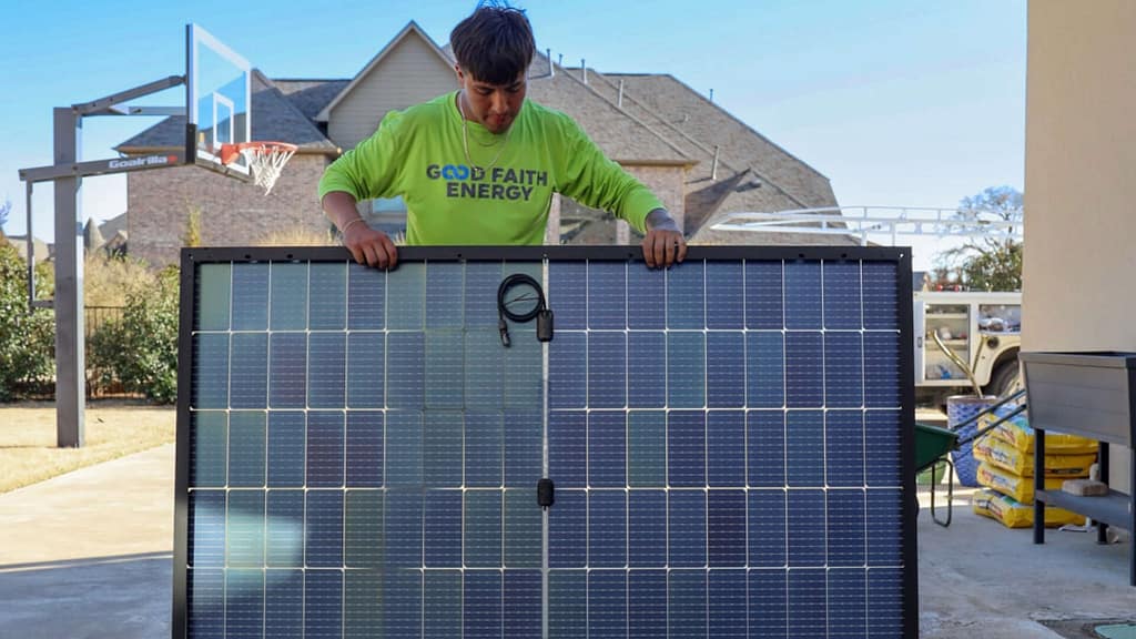 Good Faith Energy staff holding a solar panel