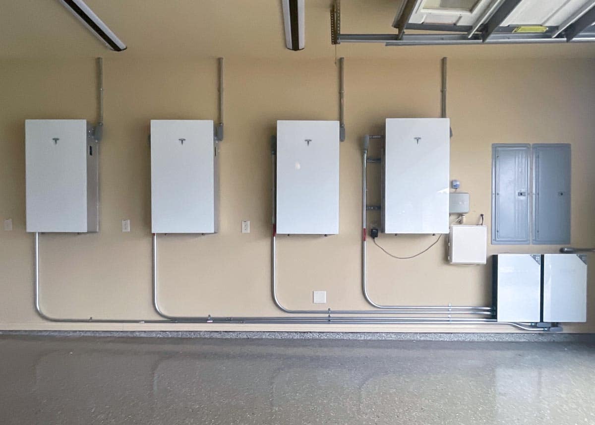 four tesla powerwalls mounted in garage