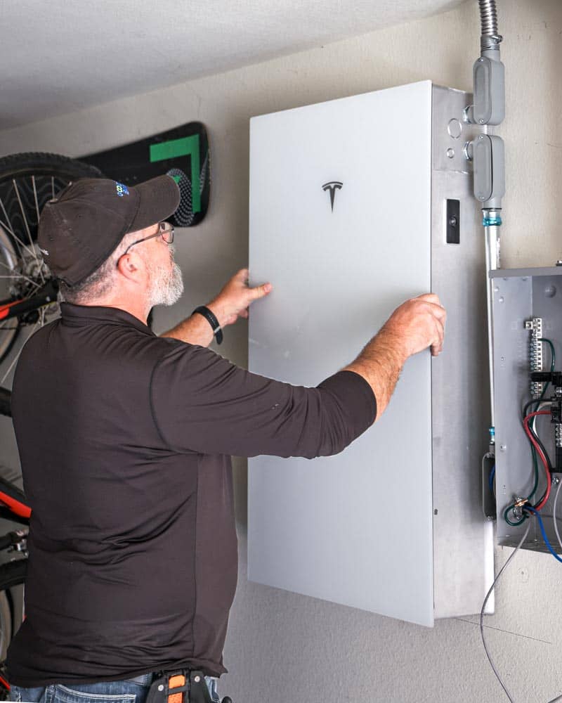 installer mounting a Powerwall 3 battery