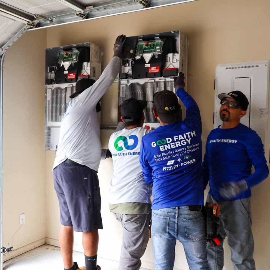 installers putting up battery backups in a residential home