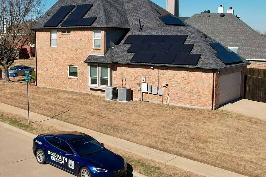 home with solar panels, and a Tesla car in front of it